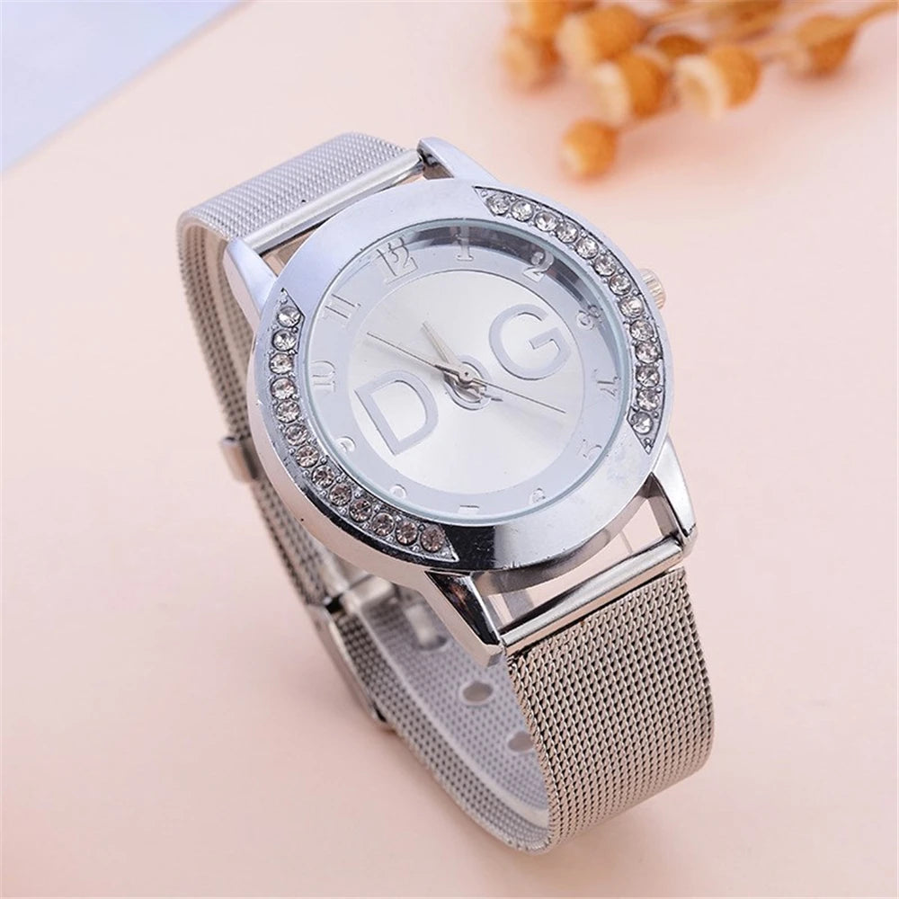 Silver watch with mesh band and diamond-like accents on a light background
